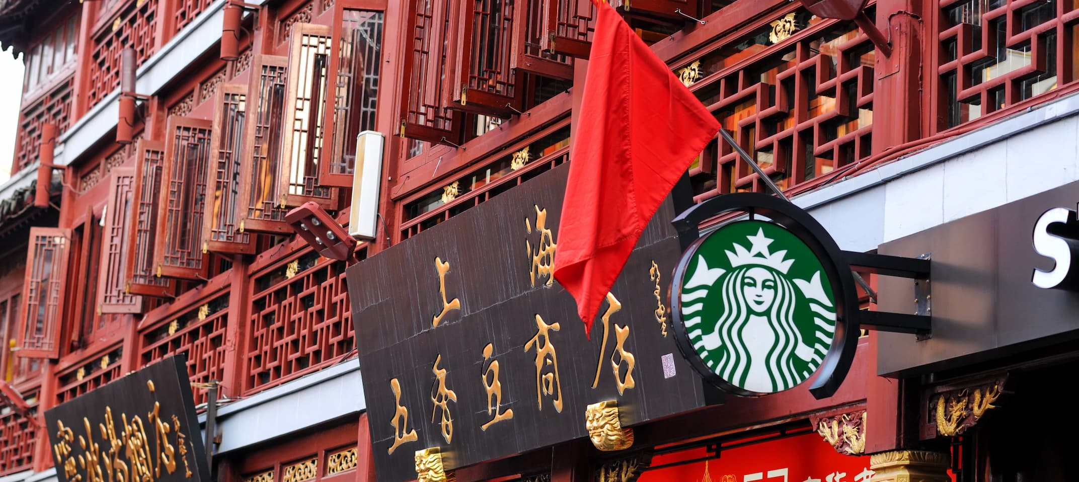 Starbucks-Logo vor traditionellem chinesischem Gebäude in Shanghai.