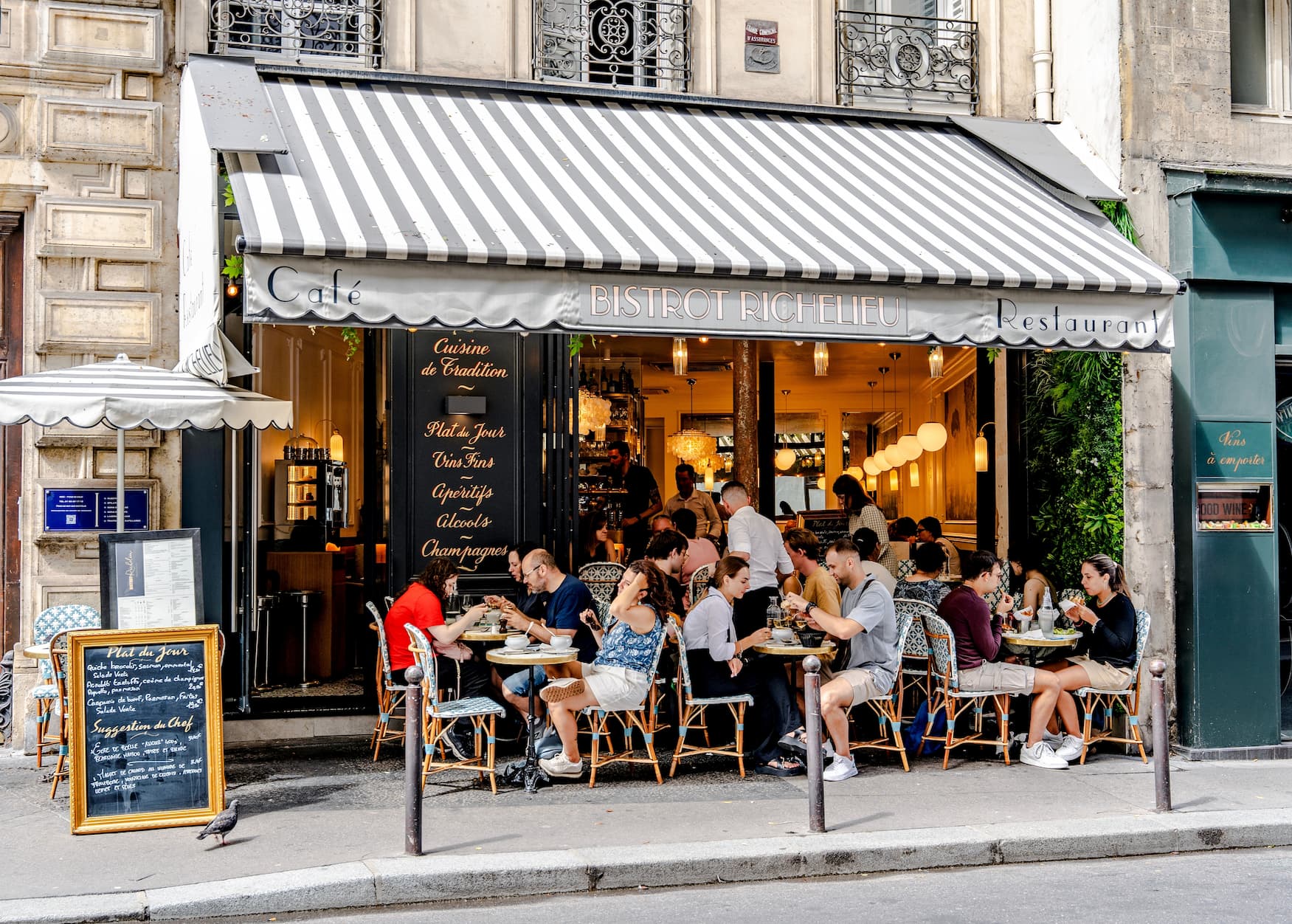 Volles Pariser Straßencafé mit Gästen im Freien.