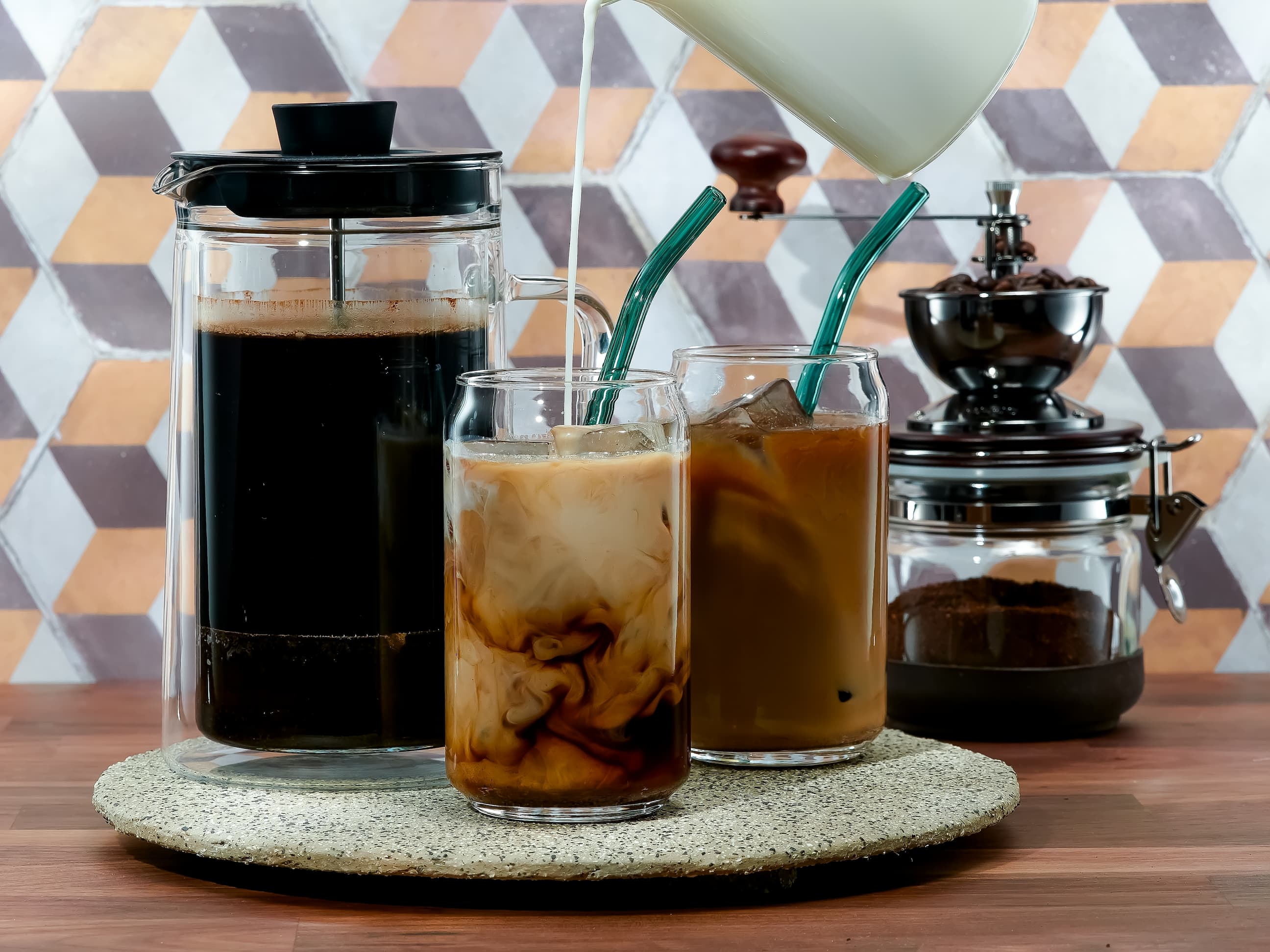 Frisch zubereiteter Iced Coffee mit Milch, serviert in Gläsern mit Strohhalmen.