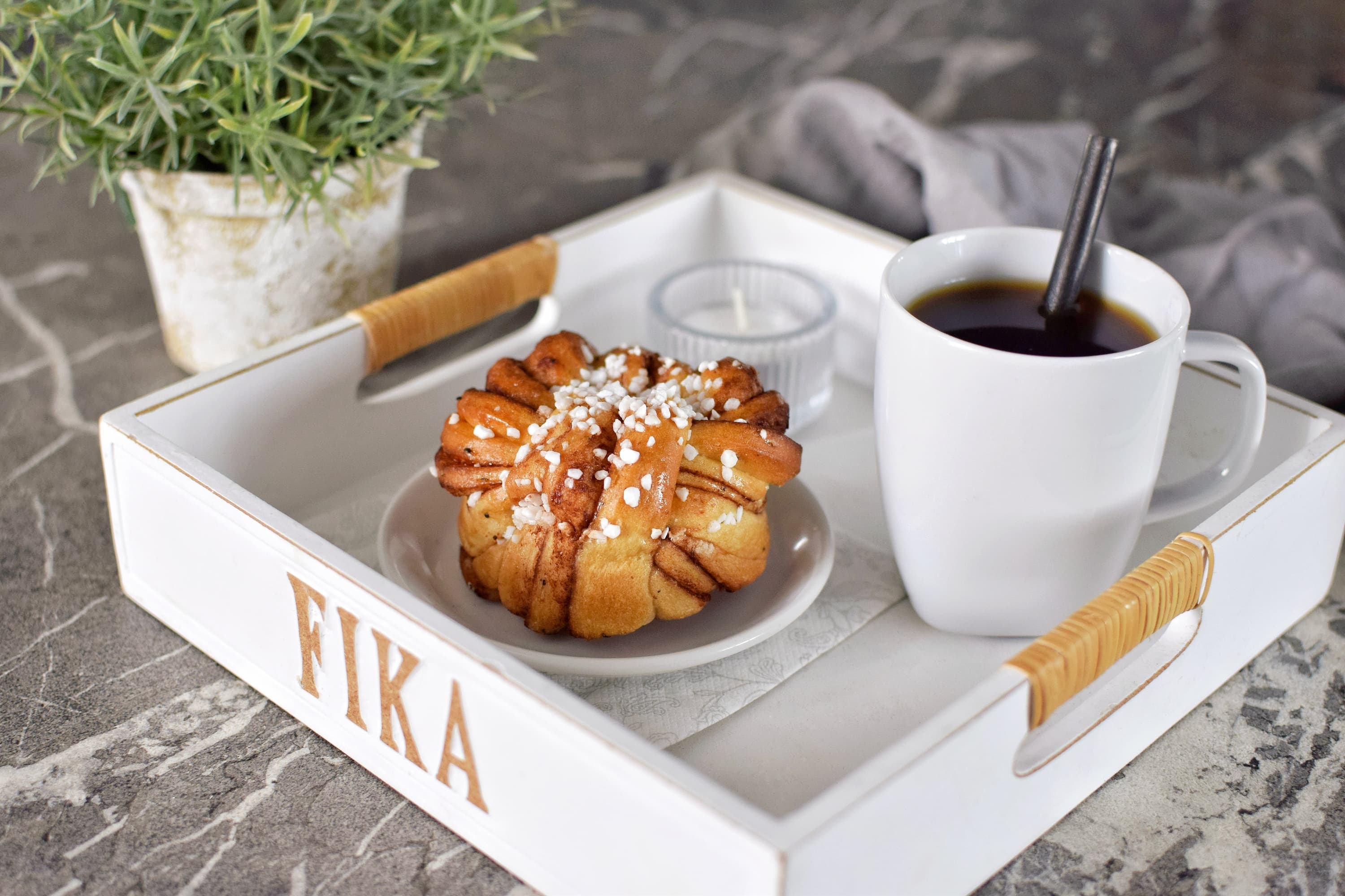 Schwedisches Fika-Tablett mit Kaffeetasse und traditioneller Zimtschnecke.