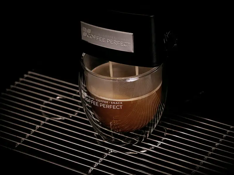 Tasse Kaffee unter einer laufenden Kaffeemaschine